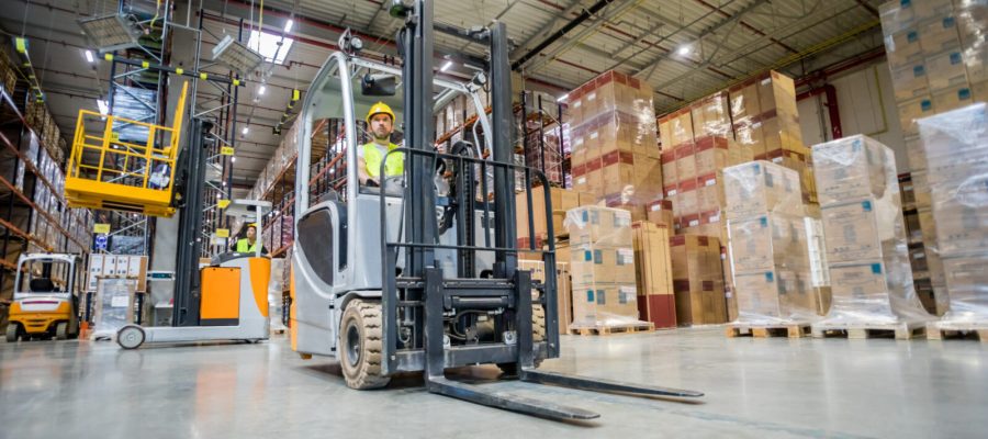 Forklift operator during work in large warehouse
